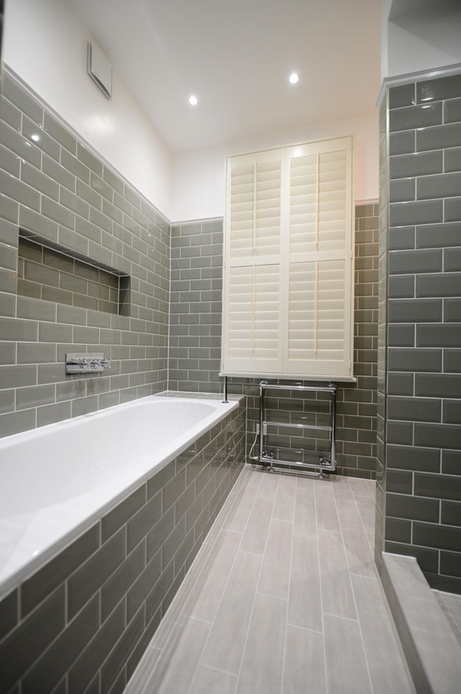 Small country bathroom in Orange County with flat-panel cabinets, medium wood cabinets, a drop-in tub, an alcove shower, a two-piece toilet, gray tile, subway tile, yellow walls, porcelain floors and a vessel sink.