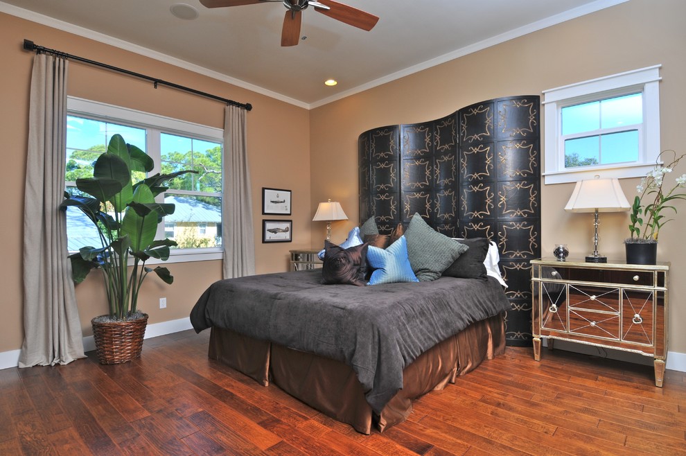Eclectic bedroom in Tampa with beige walls, medium hardwood floors and orange floor.