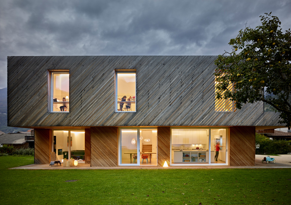Стильный дизайн: трехэтажный, деревянный, серый частный загородный дом в скандинавском стиле с двускатной крышей, серой крышей и отделкой доской с нащельником - последний тренд