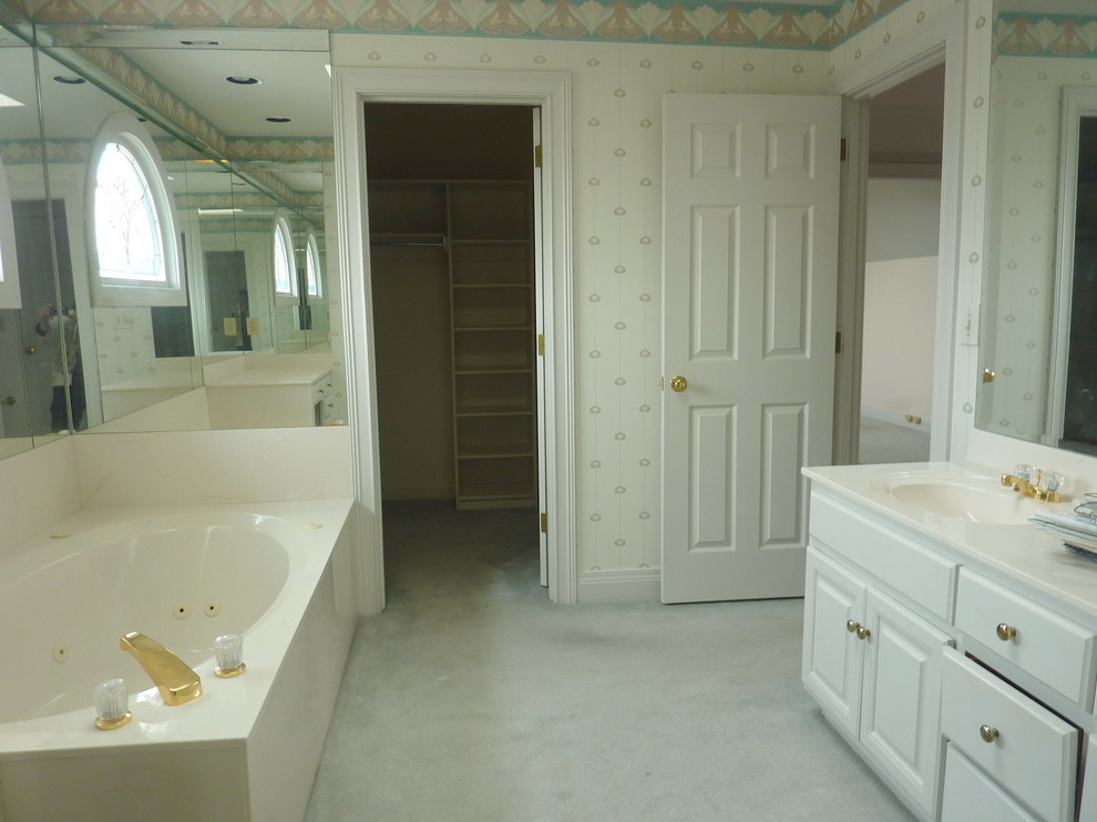 На фото: главная ванная комната среднего размера в стиле неоклассика (современная классика) с фасадами с выступающей филенкой, белыми фасадами, угловой ванной и монолитной раковиной с