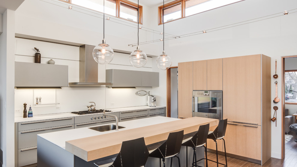 Inspiration for a mid-sized contemporary l-shaped open plan kitchen in Toronto with a single-bowl sink, flat-panel cabinets, medium hardwood floors, with island, brown cabinets, white splashback, brown floor and panelled appliances.