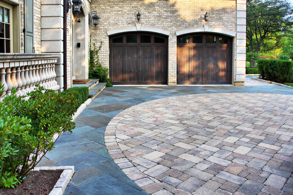 Design ideas for a traditional front yard driveway in Chicago with natural stone pavers.