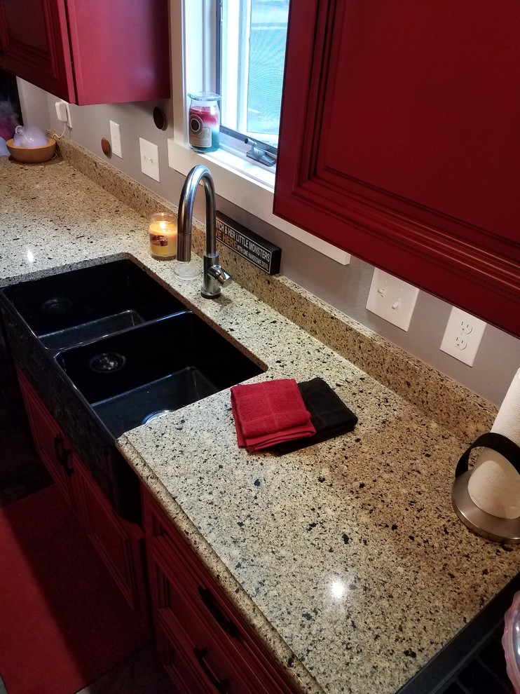 Inspiration for a l-shaped slate floor and multicolored floor enclosed kitchen remodel in Cedar Rapids with a double-bowl sink, beaded inset cabinets, red cabinets, black appliances, no island and brown countertops