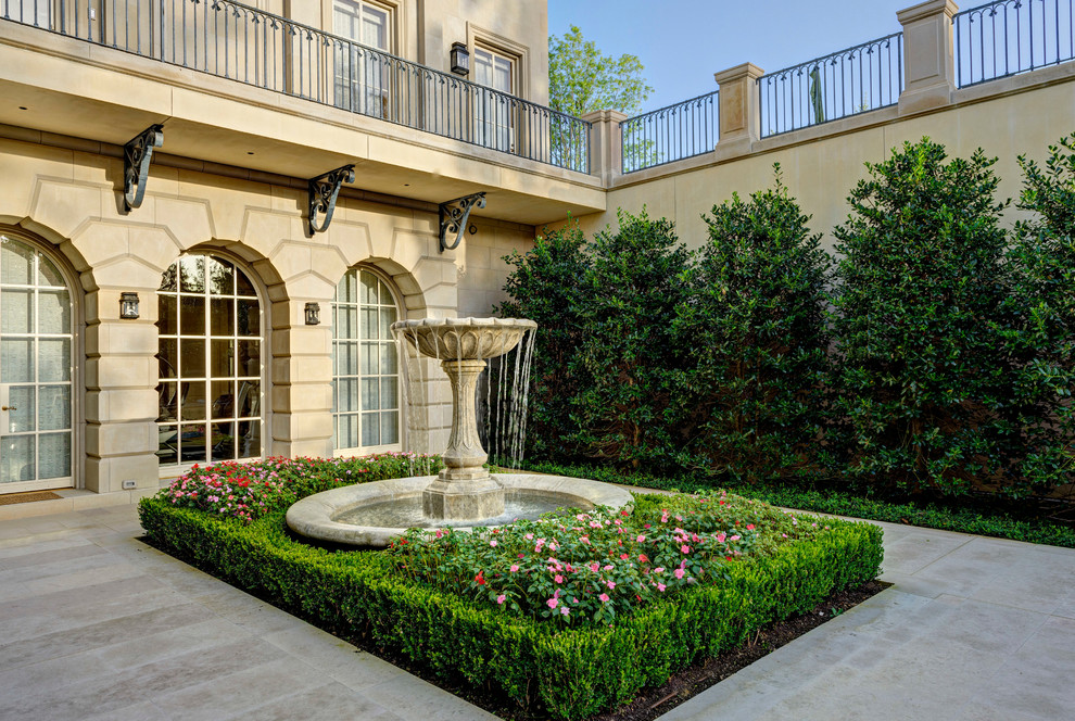This is an example of a traditional side yard full sun garden in Dallas with a water feature.