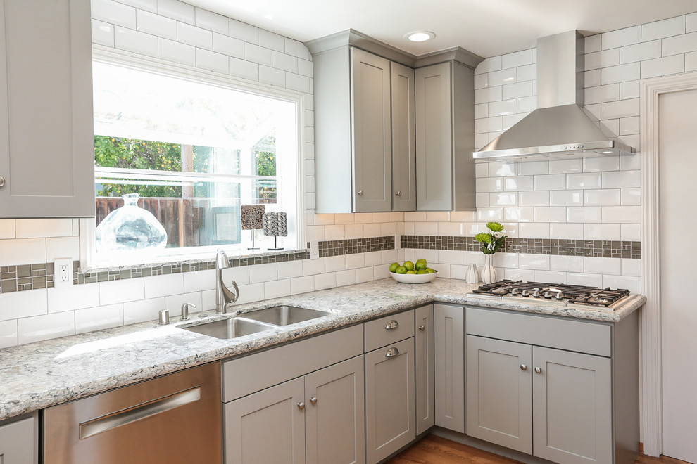 Inspiration for a small transitional eat-in kitchen in San Francisco with a double-bowl sink, shaker cabinets, grey cabinets, granite benchtops, white splashback, subway tile splashback, stainless steel appliances, medium hardwood floors and a peninsula.
