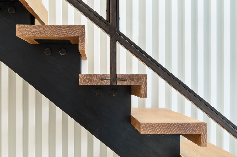 Mid-sized modern wood straight staircase in New York with open risers and metal railing.