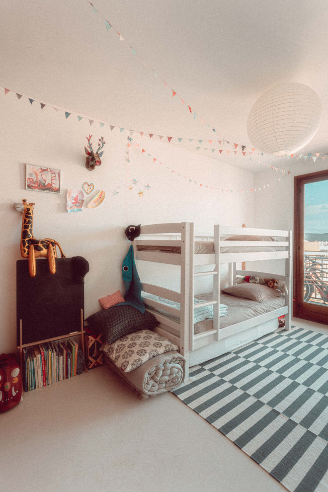 Exempel på ett mellanstort eklektiskt könsneutralt barnrum kombinerat med sovrum och för 4-10-åringar, med vita väggar, betonggolv och beiget golv