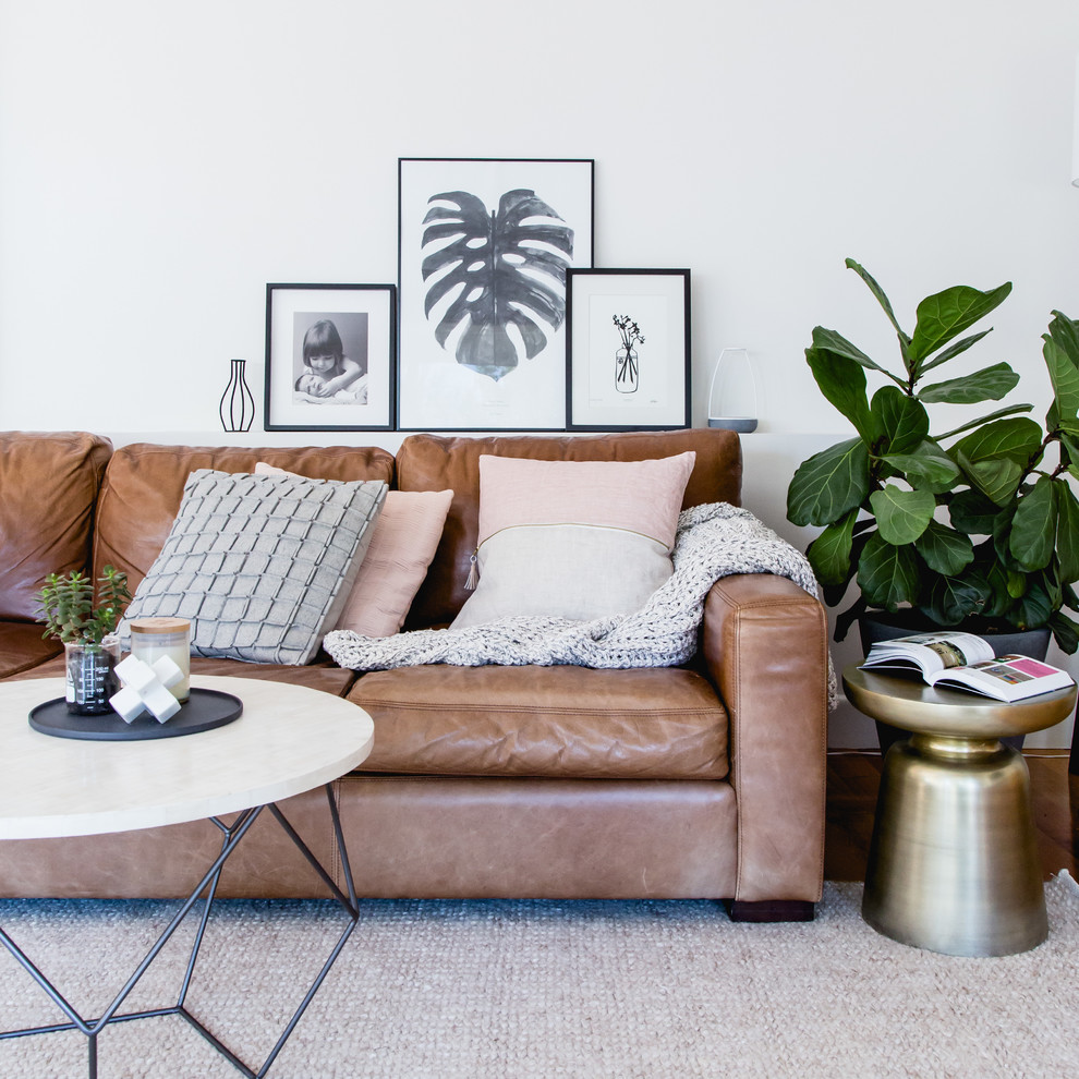 Scandinavian living room in Melbourne with white walls and medium hardwood floors.