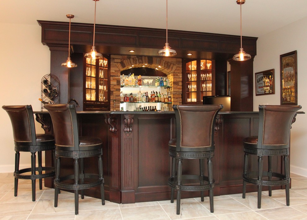 Photo of a large traditional wet bar with an undermount sink, recessed-panel cabinets, dark wood cabinets, granite benchtops, brown splashback and porcelain floors.