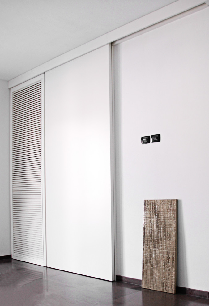 Foto på en stor funkis garderob för könsneutrala, med luckor med lamellpanel, vita skåp, målat trägolv och grått golv