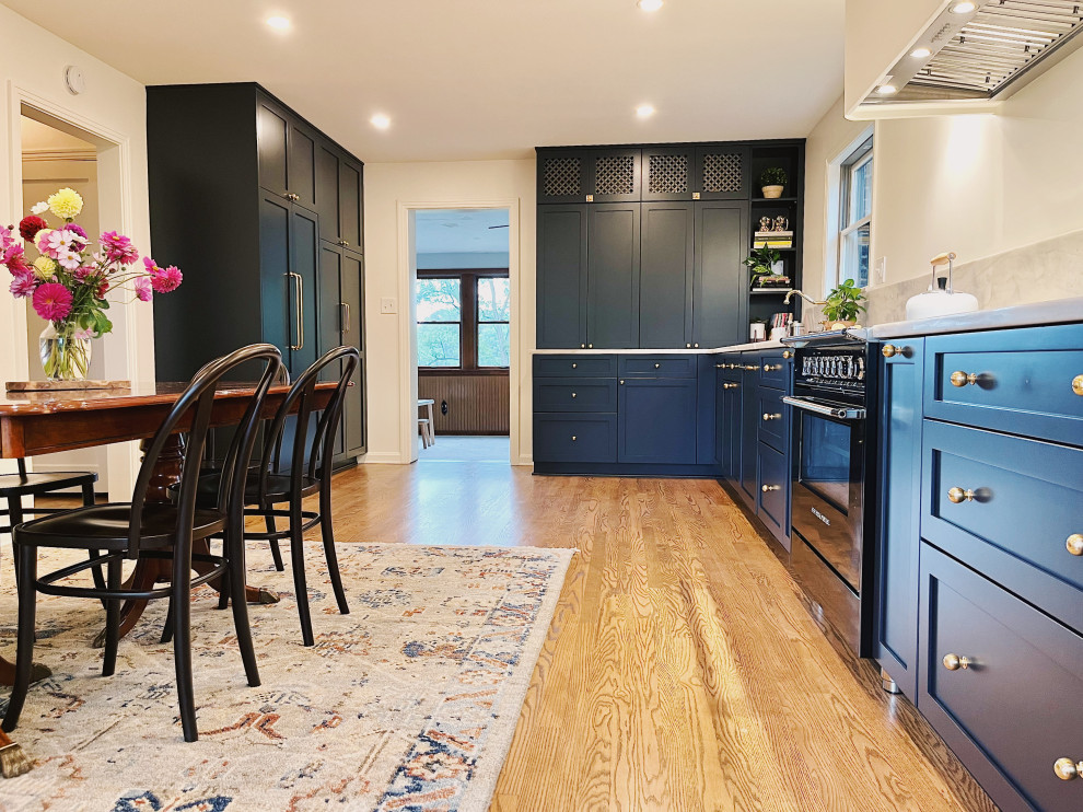 Eat-in kitchen - large transitional l-shaped medium tone wood floor and brown floor eat-in kitchen idea with an undermount sink, shaker cabinets, blue cabinets, quartzite countertops, stone slab backsplash, paneled appliances, no island and gray countertops