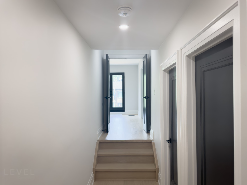 Exemple d'un couloir tendance de taille moyenne avec un mur marron, parquet clair et un sol marron.