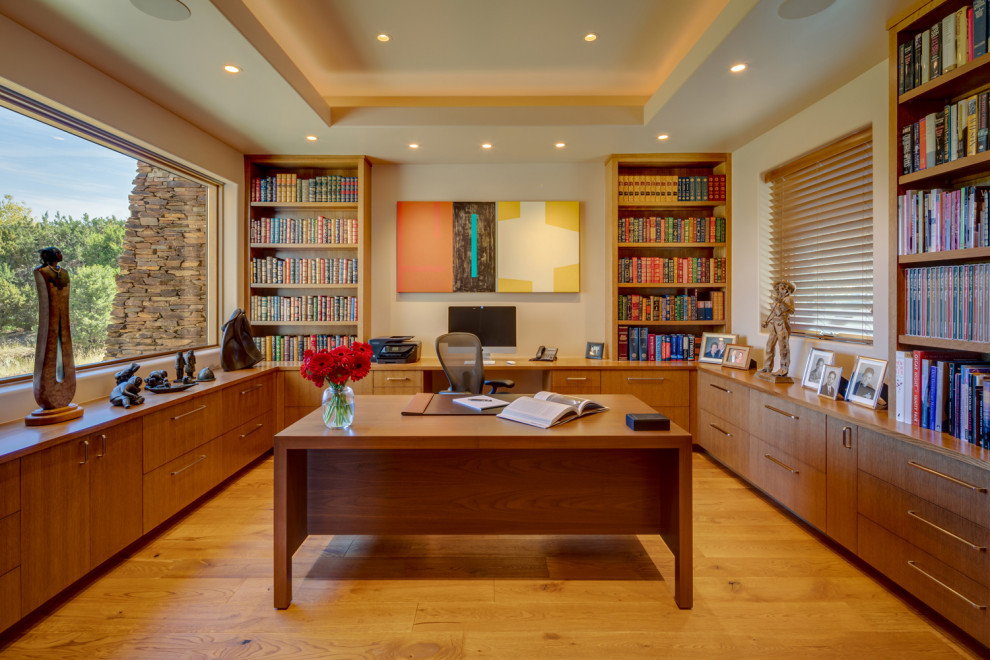 Mittelgroßes Modernes Arbeitszimmer ohne Kamin mit Studio, beiger Wandfarbe, braunem Holzboden und freistehendem Schreibtisch in Phoenix