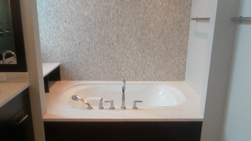 Transitional gray tile bathroom photo in Chicago with dark wood cabinets, marble countertops, an undermount tub and blue walls