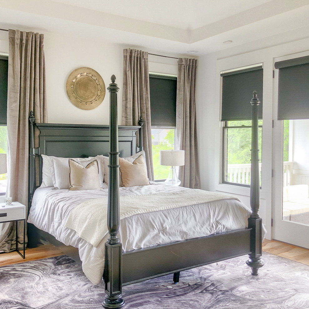 Ejemplo de dormitorio principal tradicional renovado grande con paredes blancas, suelo de madera clara, suelo marrón y bandeja