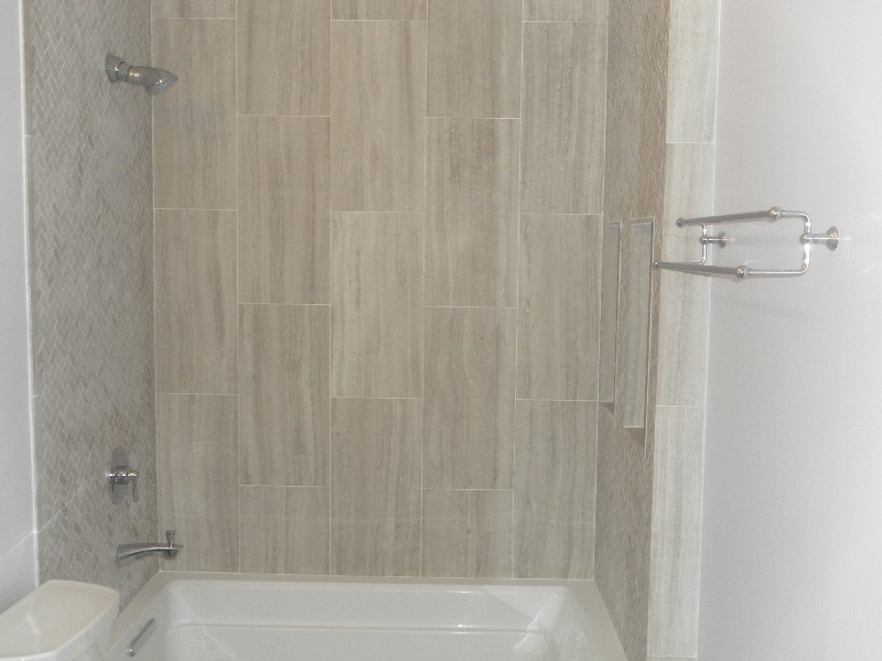 Inspiration for a transitional beige tile alcove bathtub remodel in Chicago with white walls