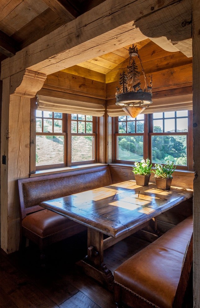 This is an example of a mid-sized country open plan dining in Denver with dark hardwood floors, brown walls, no fireplace and brown floor.
