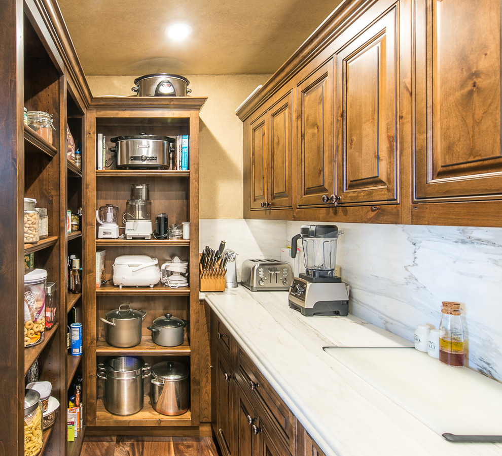 Small mountain style u-shaped dark wood floor and brown floor kitchen pantry photo in San Francisco with a farmhouse sink, raised-panel cabinets, dark wood cabinets, marble countertops, paneled appliances, an island, white backsplash and stone tile backsplash