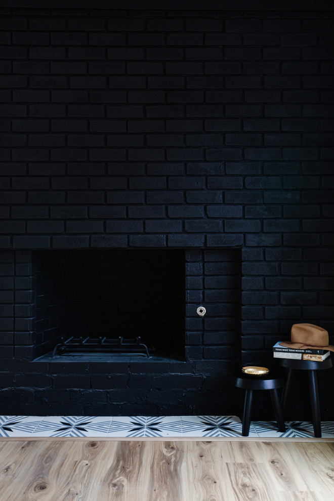 Kleines, Repräsentatives, Offenes Mid-Century Wohnzimmer mit schwarzer Wandfarbe, hellem Holzboden, Kaminumrandung aus Backstein und beigem Boden in Dallas