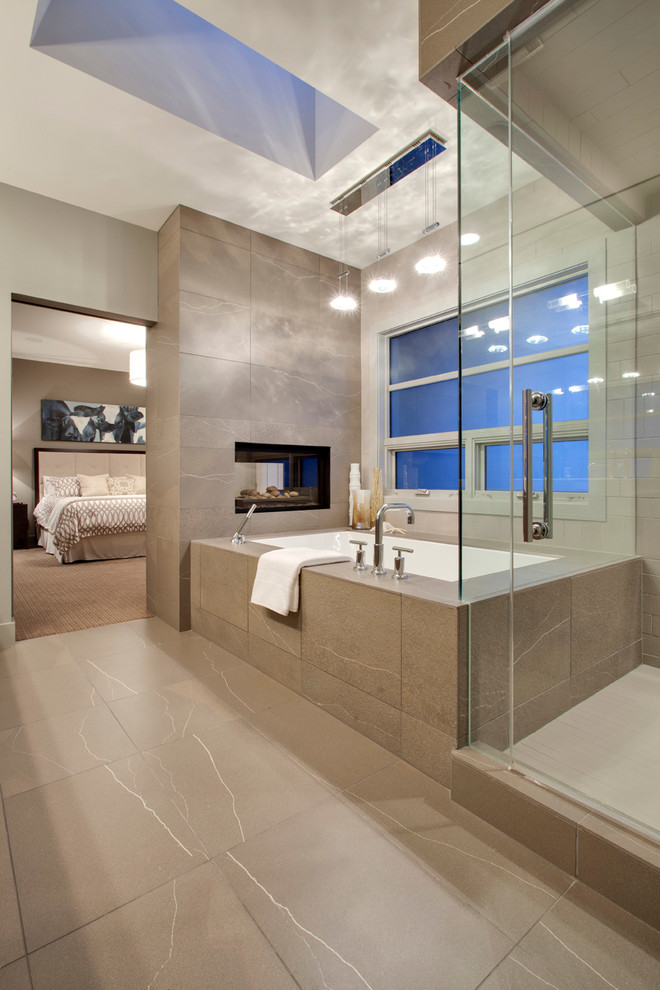 Inspiration for a contemporary bathroom in Calgary with an undermount tub and beige tile.