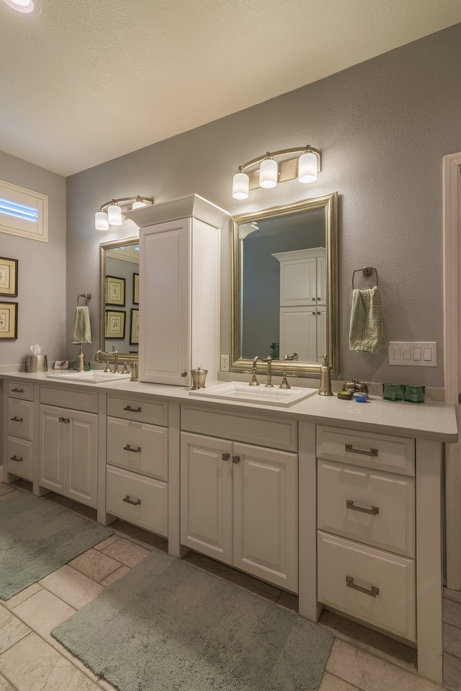 Photo of a mid-sized traditional master bathroom in Sacramento with recessed-panel cabinets, white cabinets, an alcove shower, a two-piece toilet, gray tile, ceramic tile, grey walls, ceramic floors, a drop-in sink and laminate benchtops.