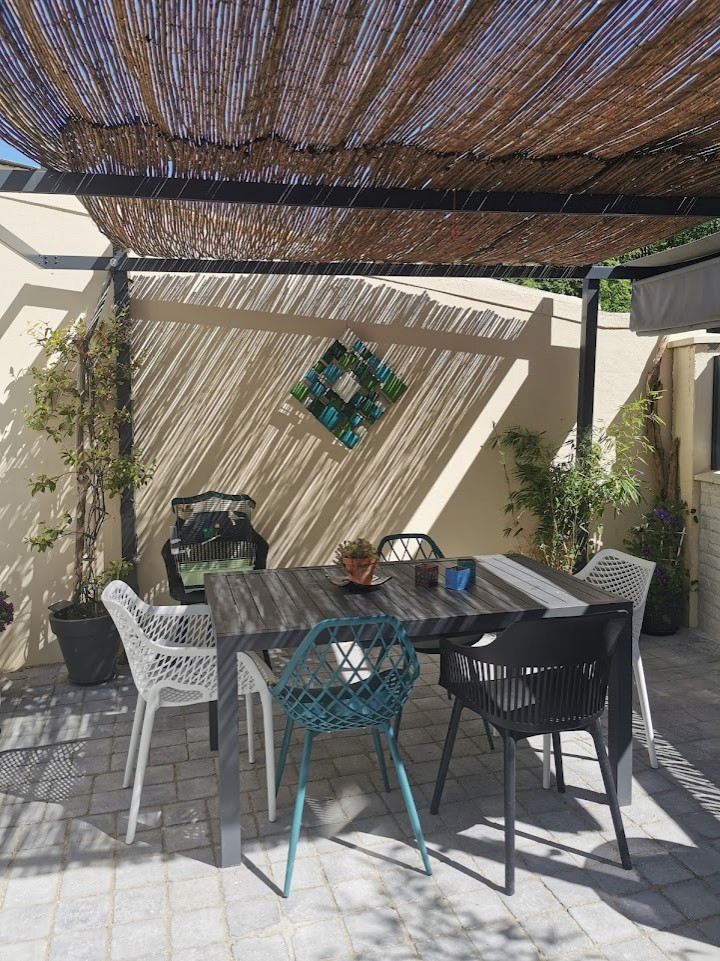 Photo of a medium sized mediterranean back full sun pergola for summer in Paris with concrete paving and a metal fence.