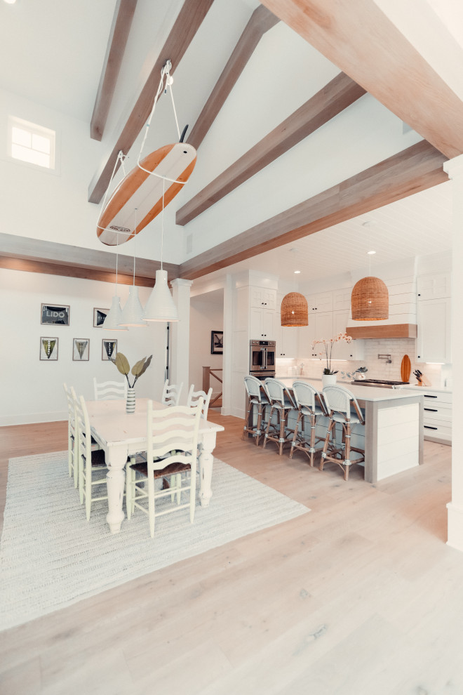 This is an example of a beach style open plan dining in Other with light hardwood floors.