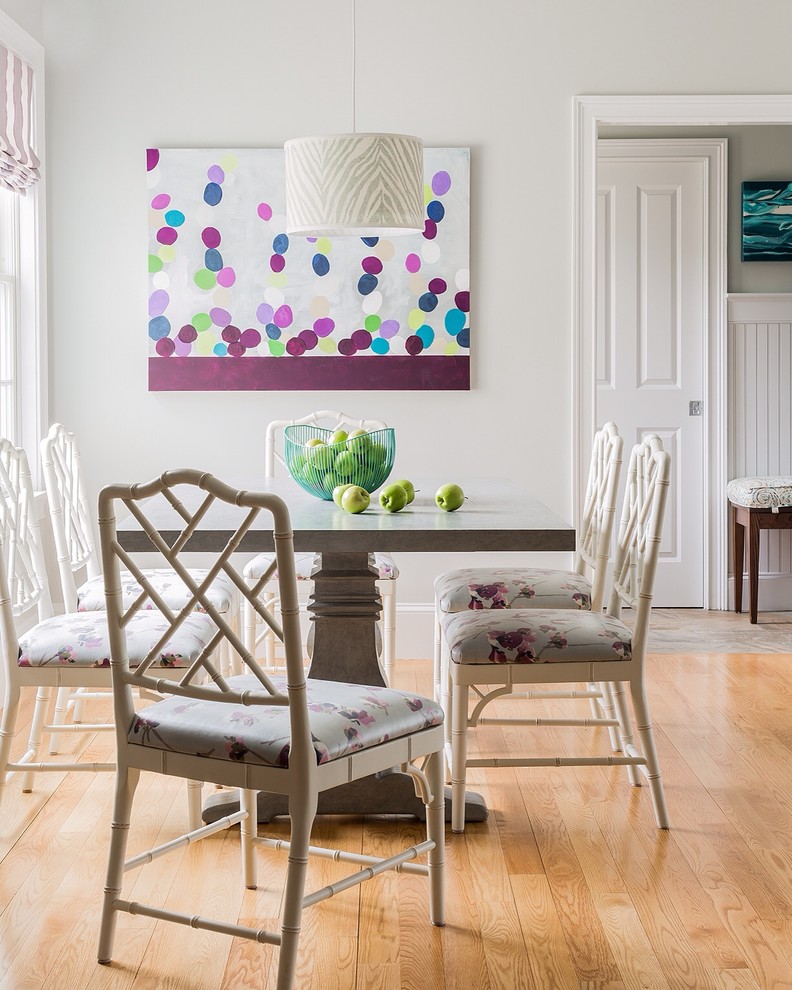 This is an example of a transitional dining room in Boston with white walls and medium hardwood floors.