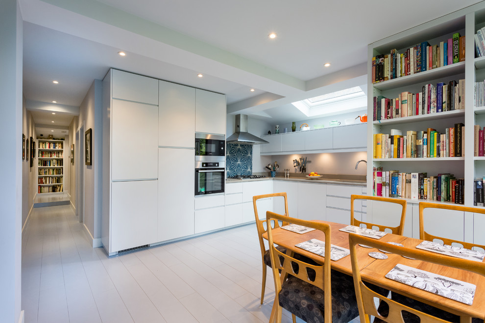 This is an example of a mid-sized transitional l-shaped eat-in kitchen in London with limestone benchtops, blue splashback, cement tile splashback, painted wood floors, no island, white floor and beige benchtop.
