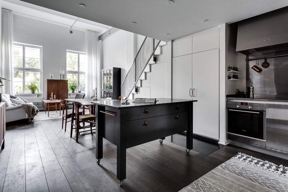 Mid-sized scandinavian kitchen in Stockholm with limestone benchtops, dark hardwood floors and with island.
