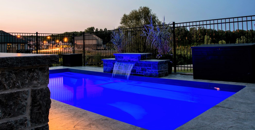 Example of a small minimalist backyard stamped concrete and rectangular pool design