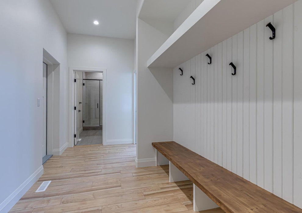 Idéer för att renovera ett mellanstort lantligt walk-in-closet för könsneutrala, med ljust trägolv och beiget golv