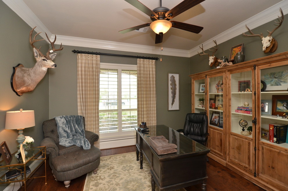 Mid-sized country study room in Houston with a freestanding desk, green walls, dark hardwood floors, no fireplace and brown floor.