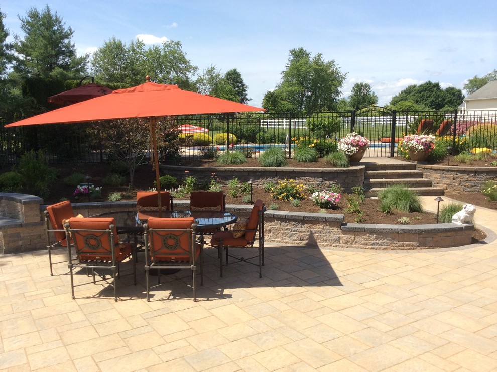 This is an example of an expansive backyard patio in Newark with concrete pavers.