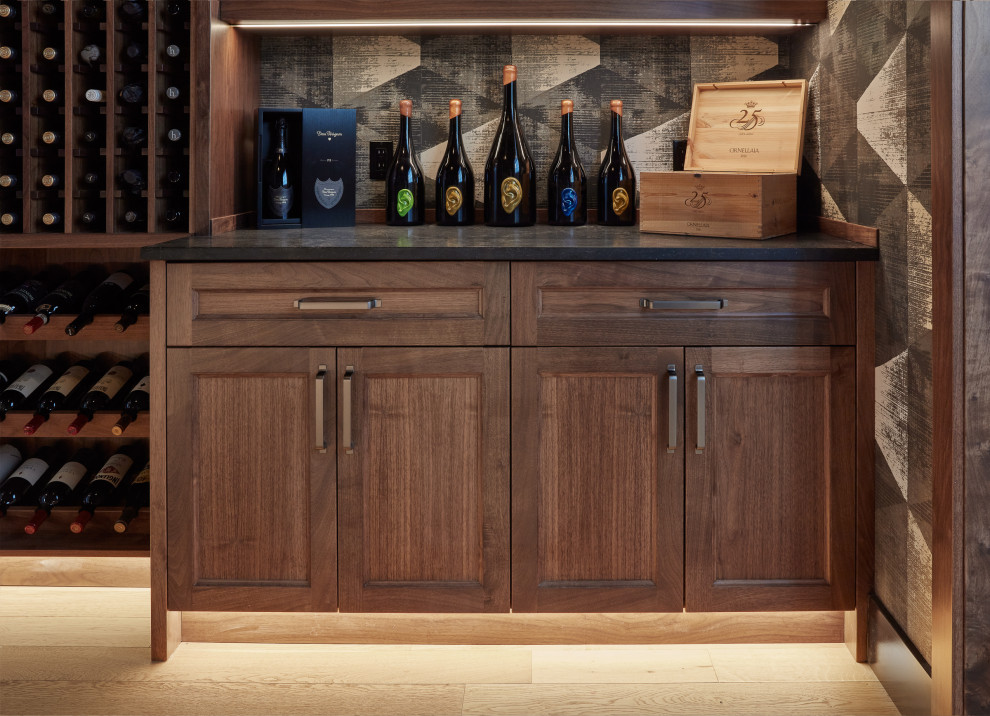 Inspiration for a mid-sized industrial light wood floor and beige floor wine cellar remodel in Edmonton with display racks
