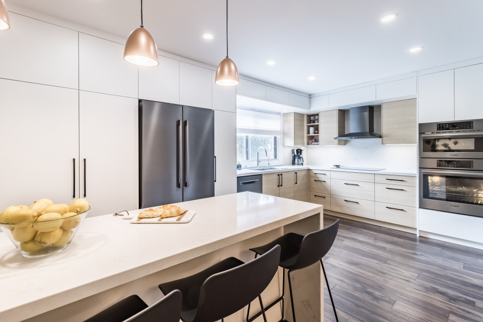 Inspiration for a medium sized modern l-shaped kitchen/diner in Toronto with a double-bowl sink, flat-panel cabinets, white cabinets, engineered stone countertops, white splashback, engineered quartz splashback, white appliances, an island and white worktops.