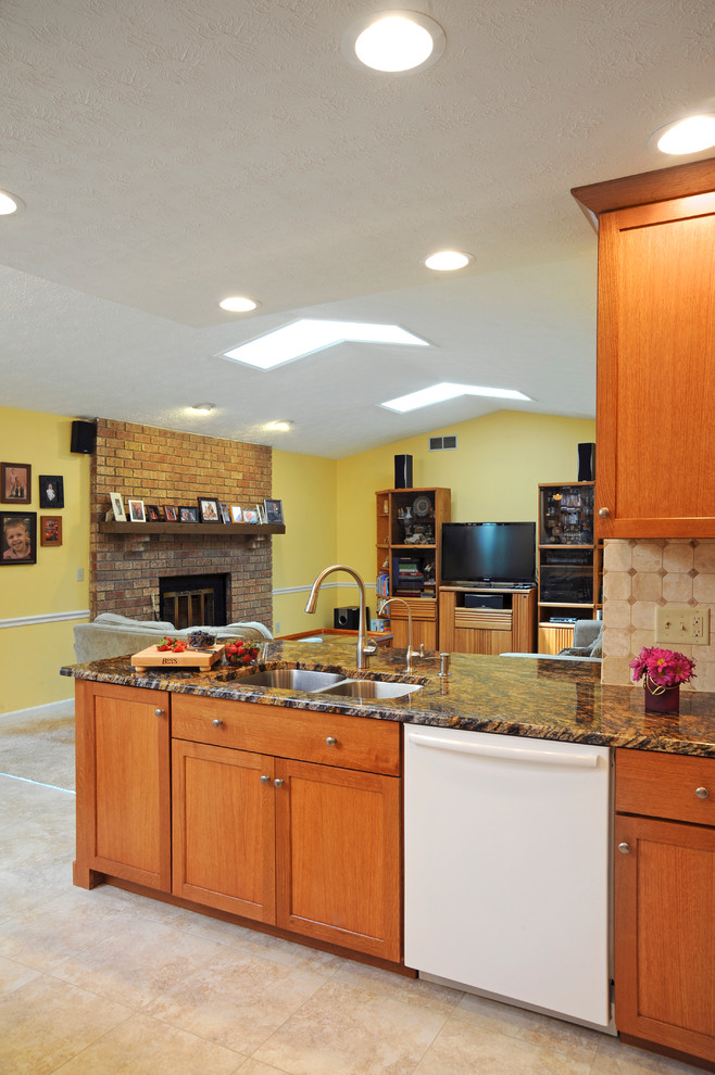 Example of a mid-sized transitional u-shaped limestone floor and beige floor eat-in kitchen design in Cincinnati with a double-bowl sink, shaker cabinets, medium tone wood cabinets, granite countertops, beige backsplash, ceramic backsplash, stainless steel appliances and a peninsula