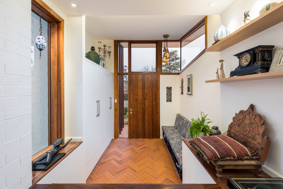 Photo of a contemporary entryway in Canberra - Queanbeyan with a dark wood front door.