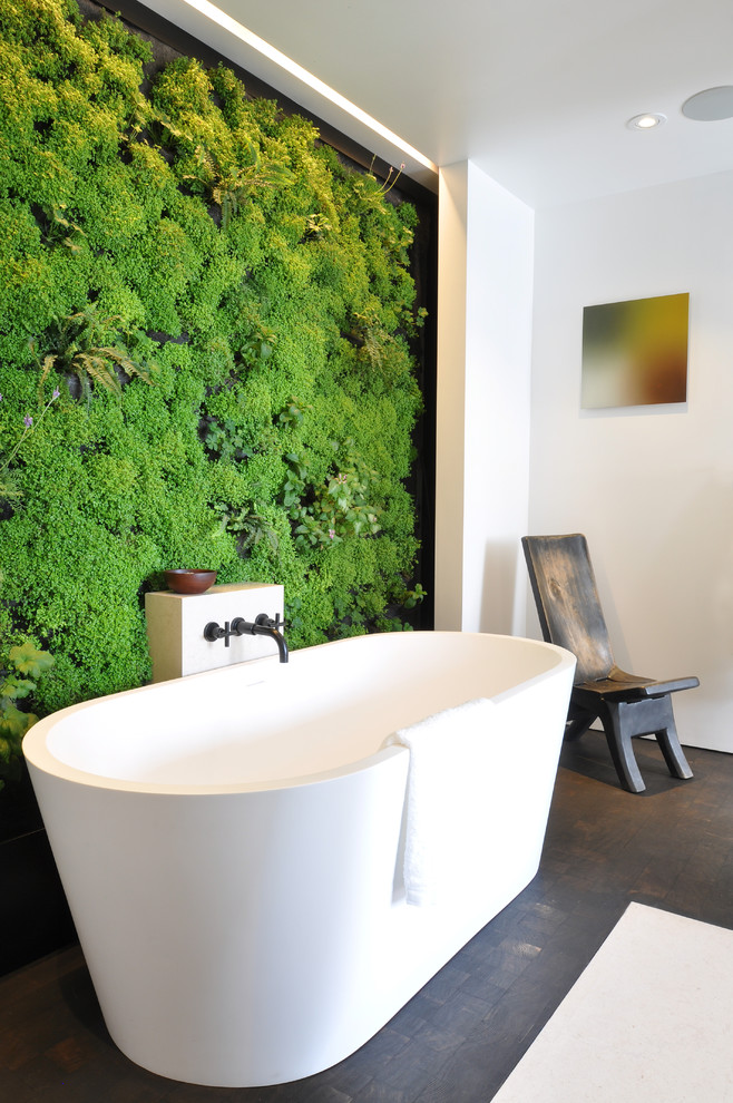 This is an example of a contemporary bathroom in San Francisco with a freestanding tub and green walls.
