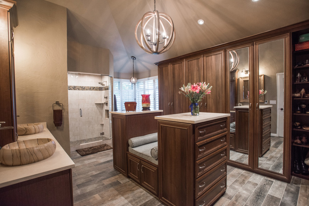 Large contemporary walk-in wardrobe in Louisville with recessed-panel cabinets, dark wood cabinets, limestone floors and grey floor.