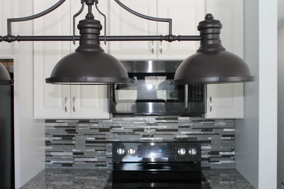 Inspiration for a mid-sized transitional u-shaped dark wood floor and brown floor kitchen remodel with an undermount sink, raised-panel cabinets, white cabinets, granite countertops, multicolored backsplash, matchstick tile backsplash, stainless steel appliances and an island
