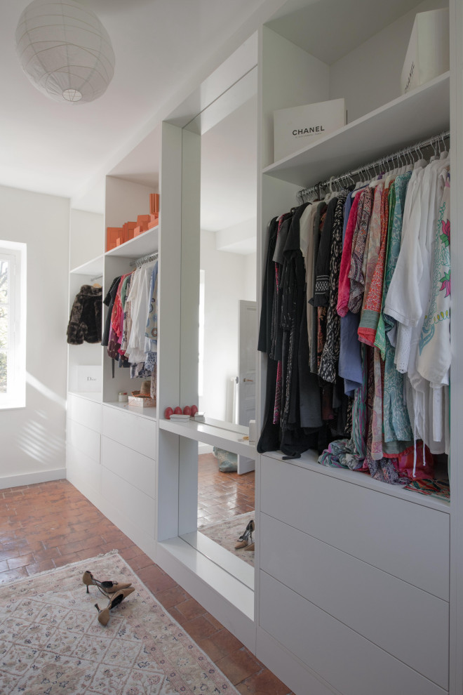 Design ideas for a large classic dressing room for women in Lyon with beaded cabinets, white cabinets and terracotta flooring.