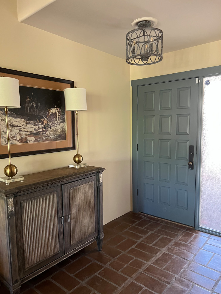 フェニックスにあるお手頃価格の中くらいなラスティックスタイルのおしゃれな玄関ロビー (ベージュの壁、テラコッタタイルの床、青いドア、赤い床) の写真