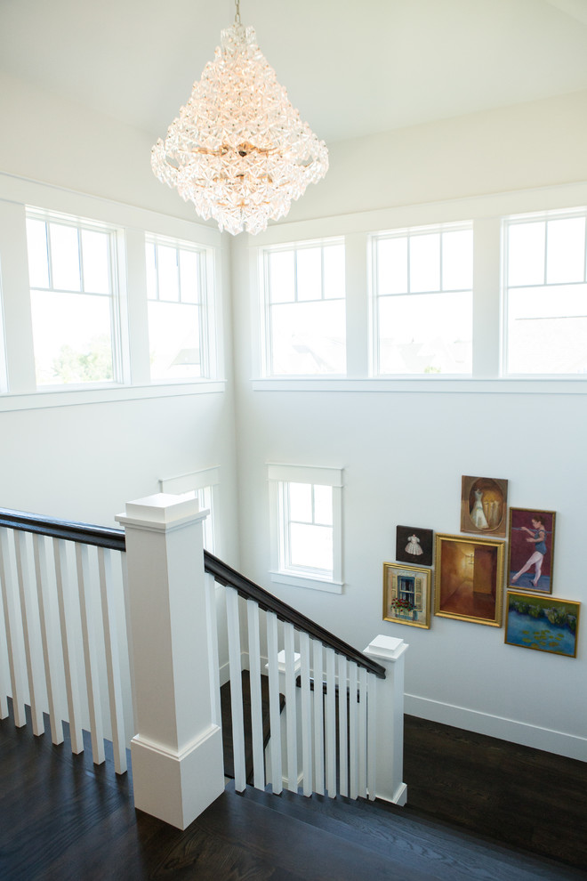 This is an example of a large transitional wood u-shaped staircase in Other with wood risers and wood railing.