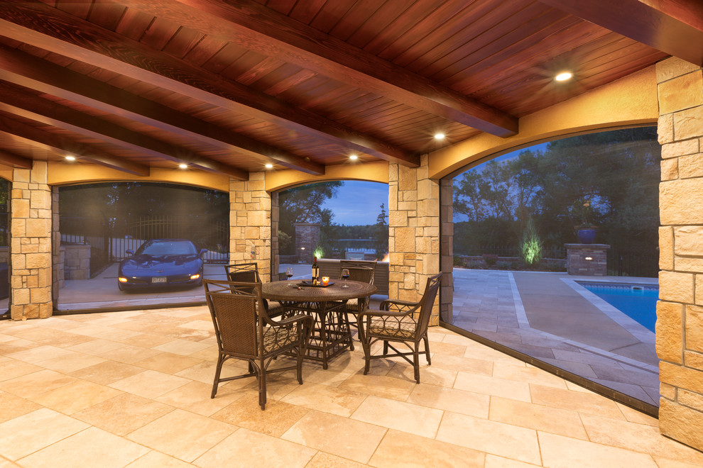 This is an example of a large traditional backyard patio in Minneapolis with a roof extension.
