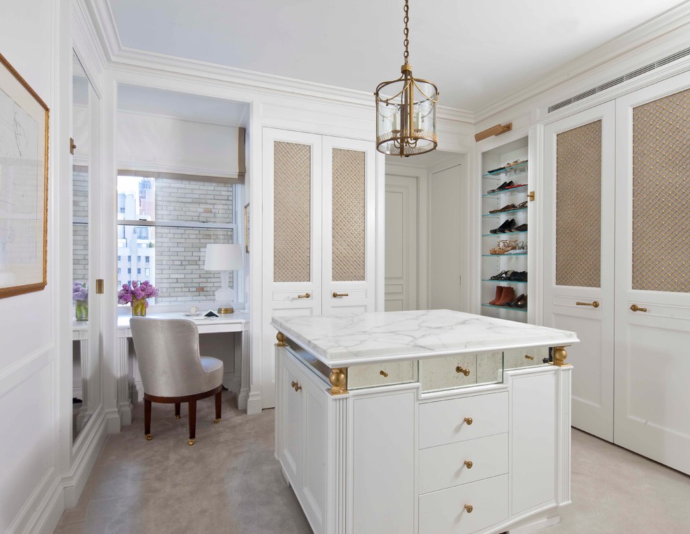 Inspiration for a traditional women's dressing room in New York with recessed-panel cabinets and white cabinets.