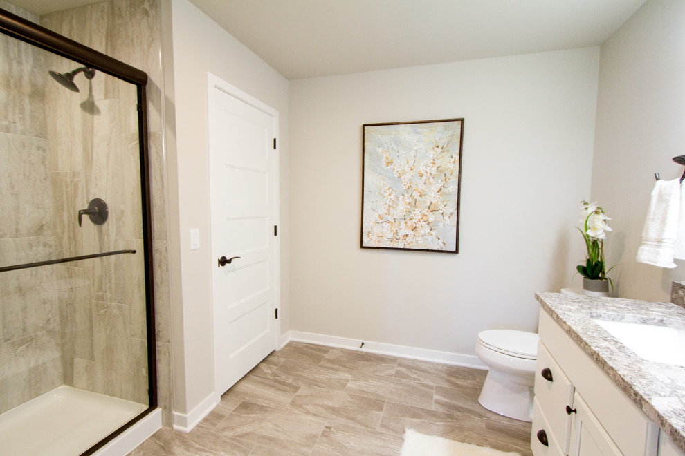 Ispirazione per una stanza da bagno tradizionale con ante bianche, doccia alcova, pareti beige, lavabo sottopiano, top in quarzo composito e pavimento beige