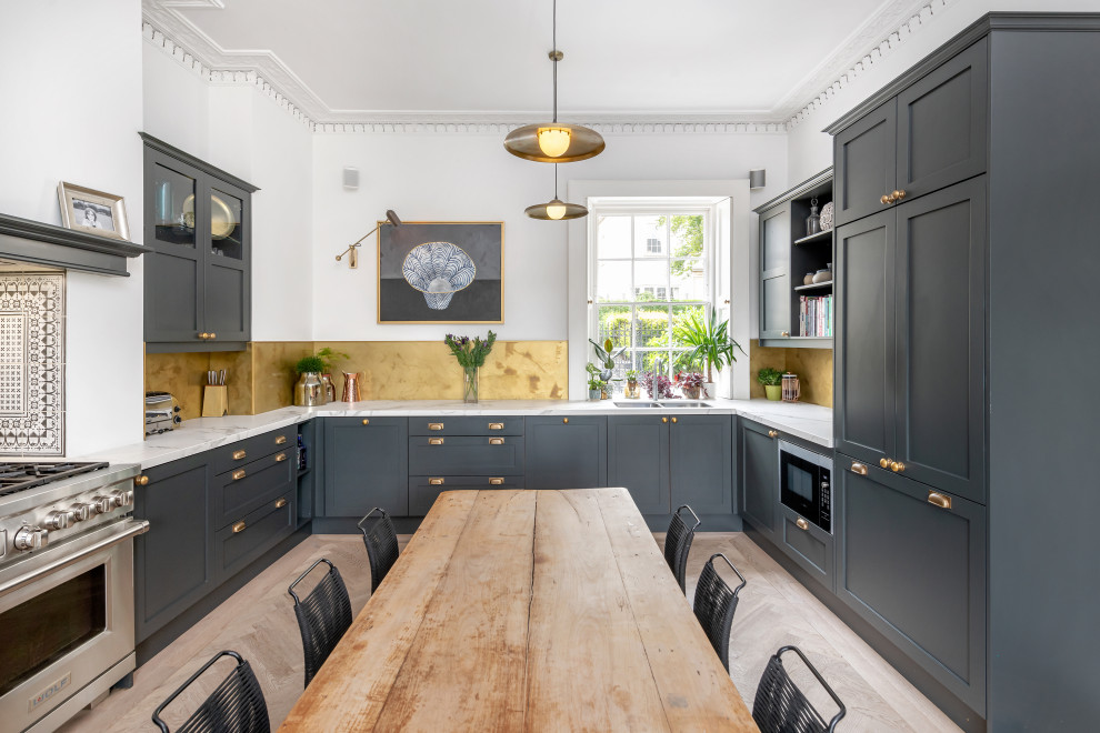 Inspiration for a large traditional u-shaped kitchen/diner in Other with shaker cabinets, black cabinets, a chimney breast, a double-bowl sink, marble worktops, metallic splashback, integrated appliances, light hardwood flooring, beige floors and multicoloured worktops.