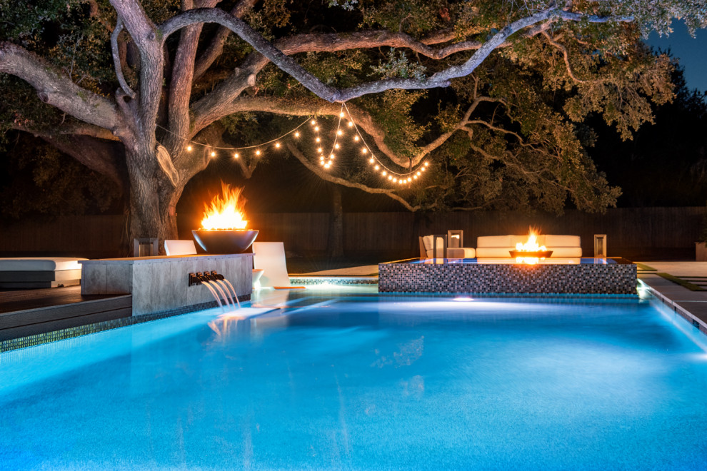 Ejemplo de piscina romántica grande rectangular en patio trasero con adoquines de piedra natural