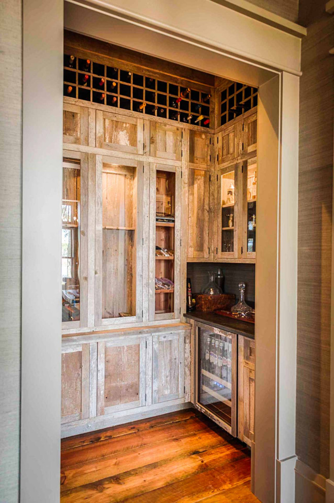 Wine cellar - medium tone wood floor and brown floor wine cellar idea in Other